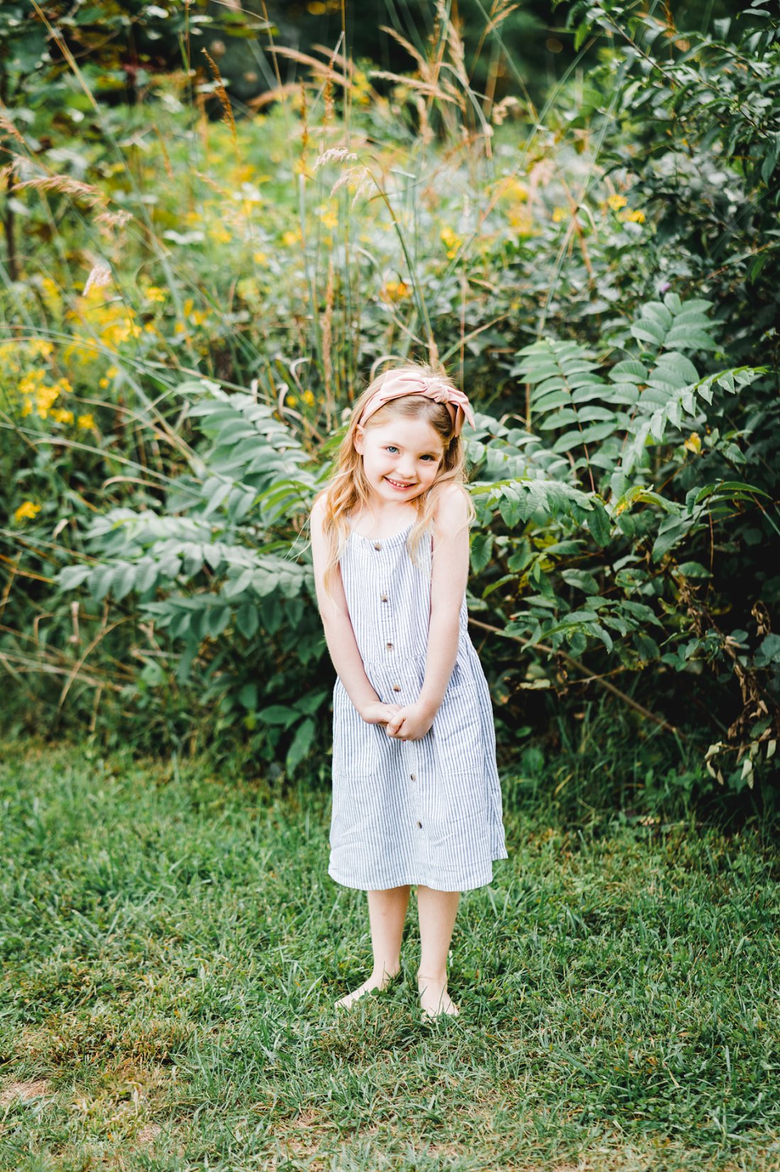 little girl standing in grass