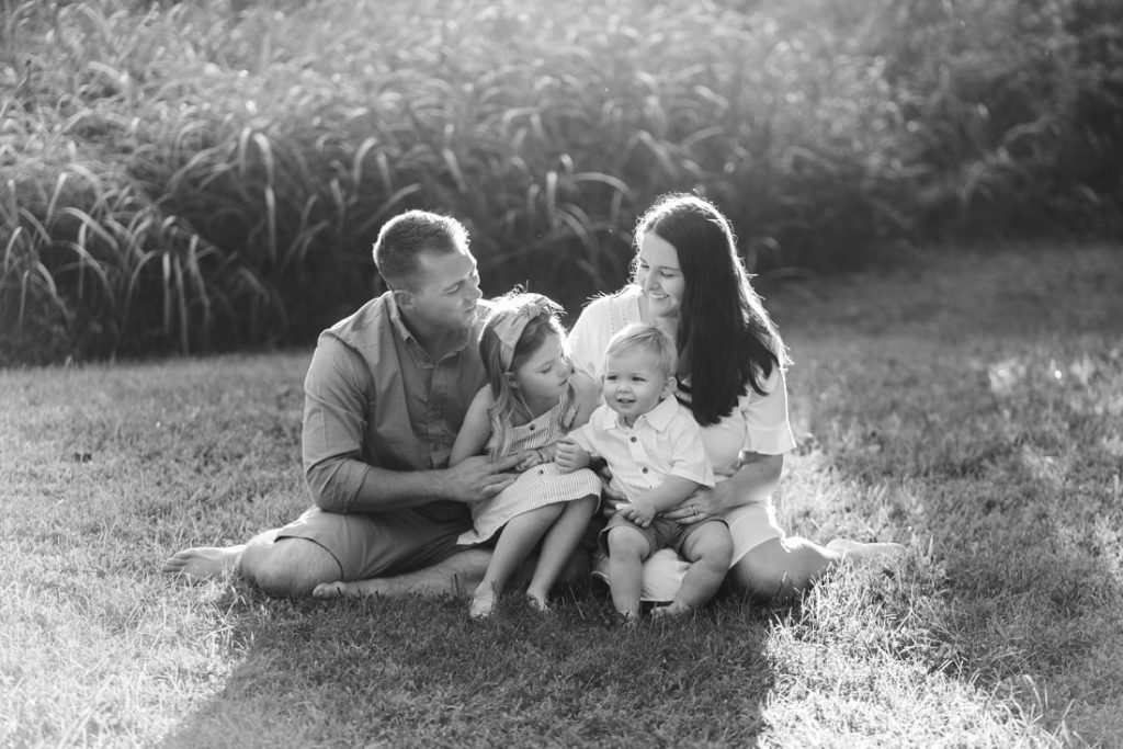 black and white photo of family sitting in grass | Family Photographers Montgomery Alabama | Melissa Sheridan Photography
