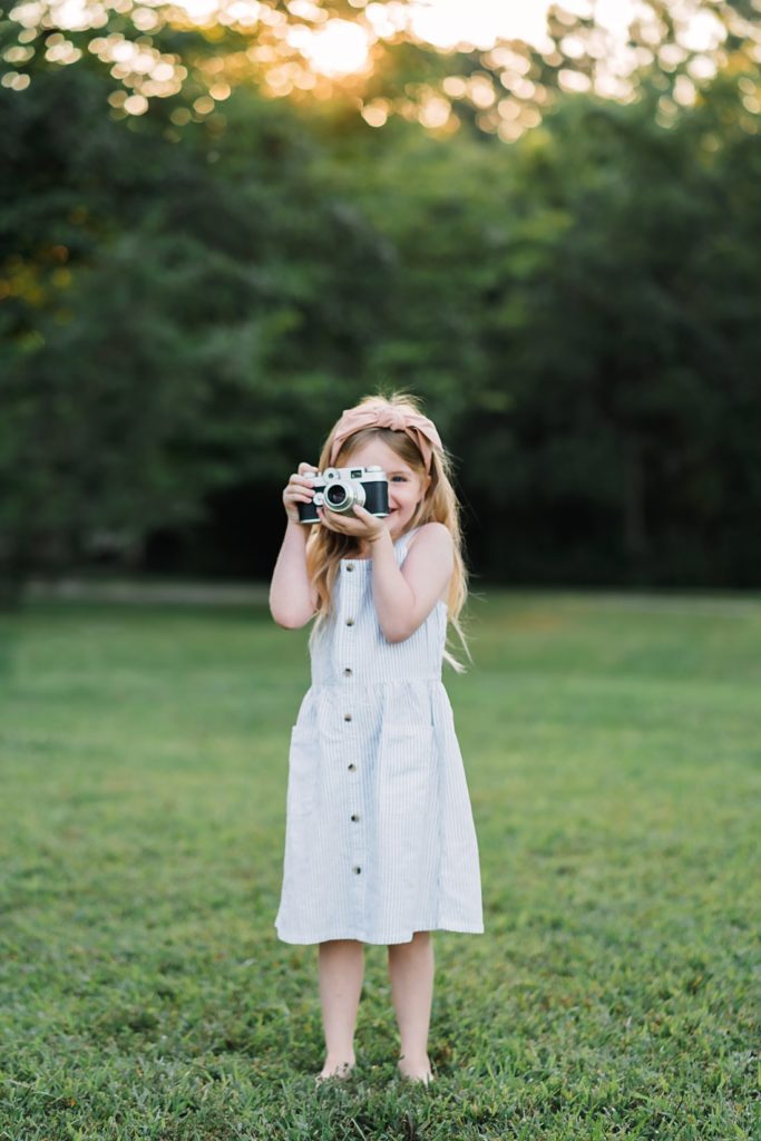 little girl holding camera up to her face | Montgomery Children's Photographer