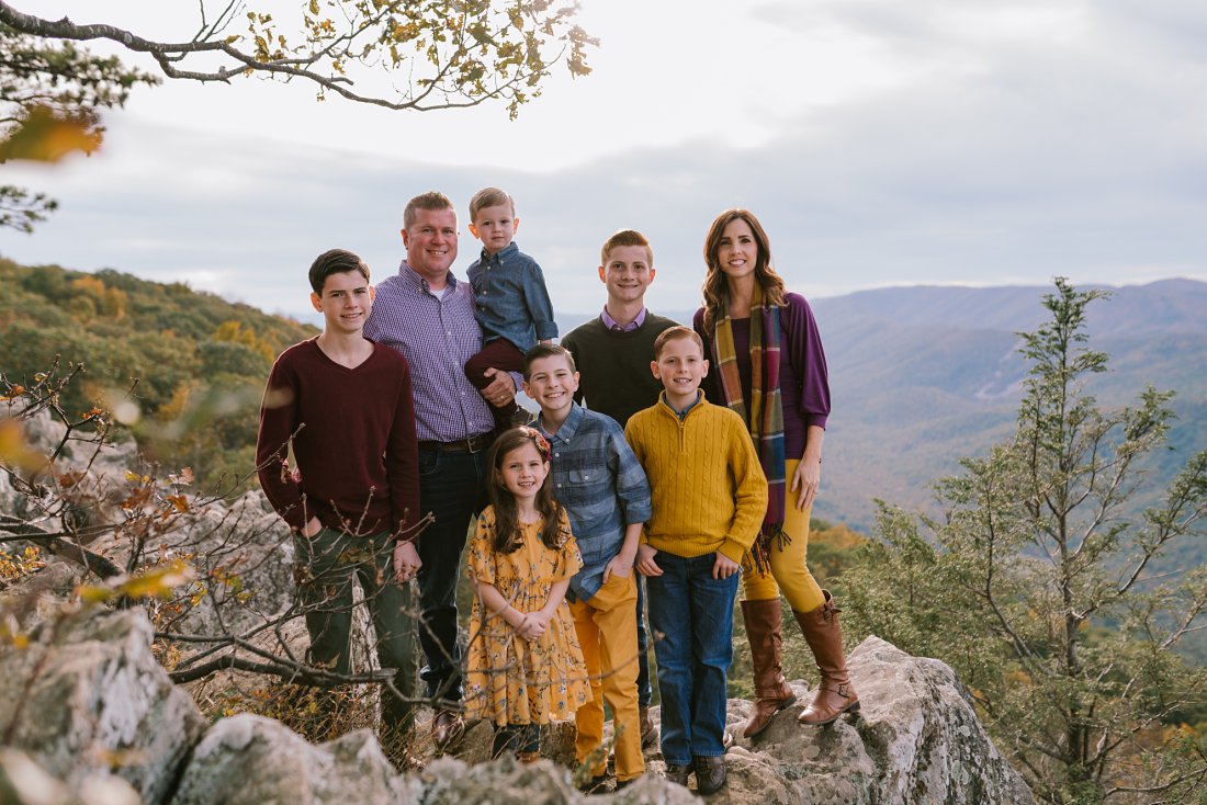 family standing on mountainside in fall clothes