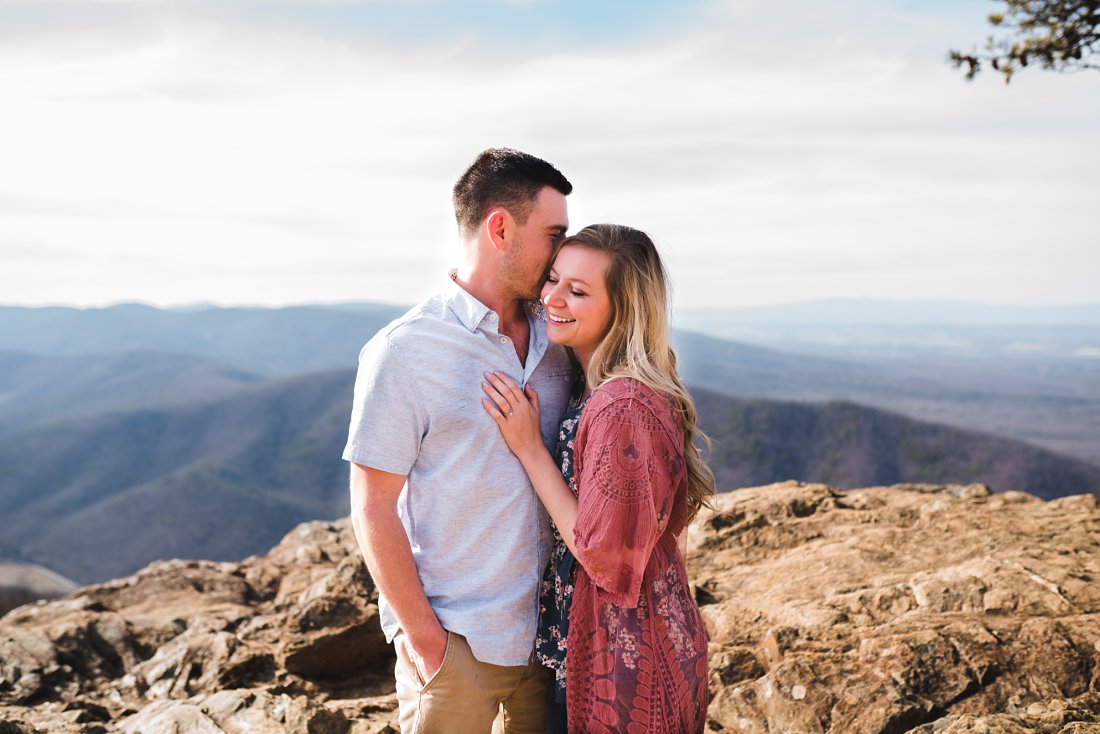 couple standing close together on mountaintop