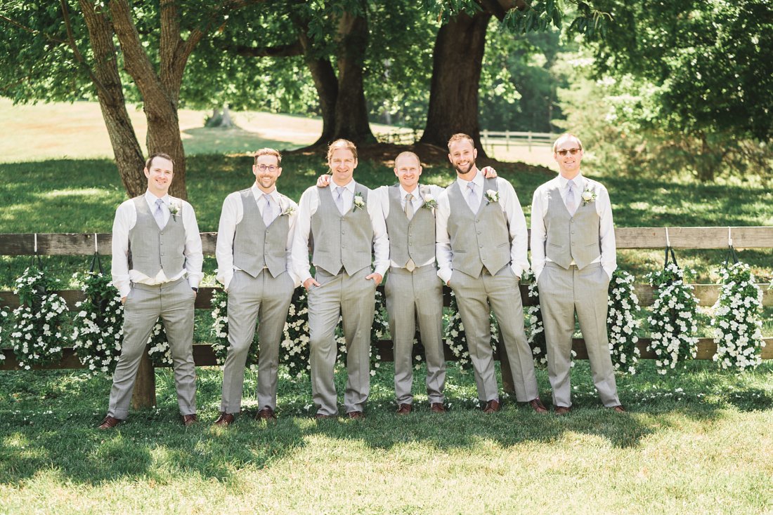 Groom with his groomsmen standing together in front of flowers | Richmond Wedding Photographer