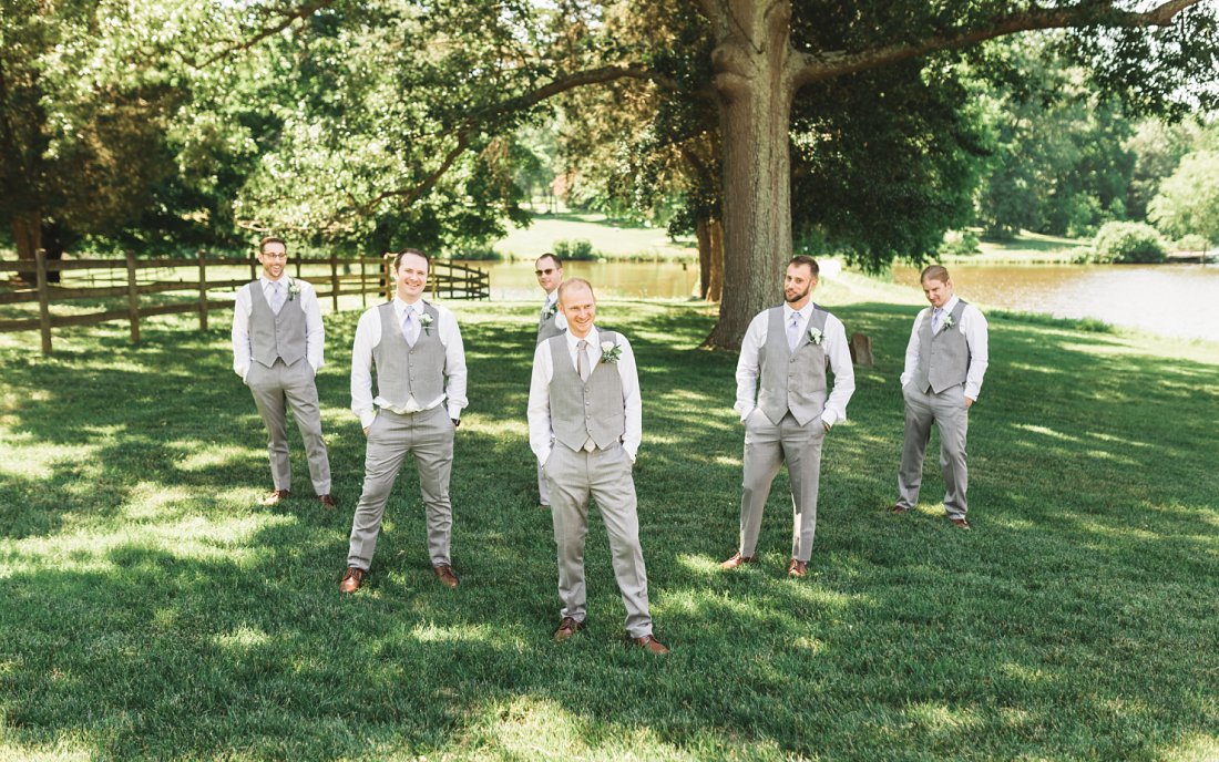 Groom with his groomsmen in the grass | Running Mare Farm Wedding