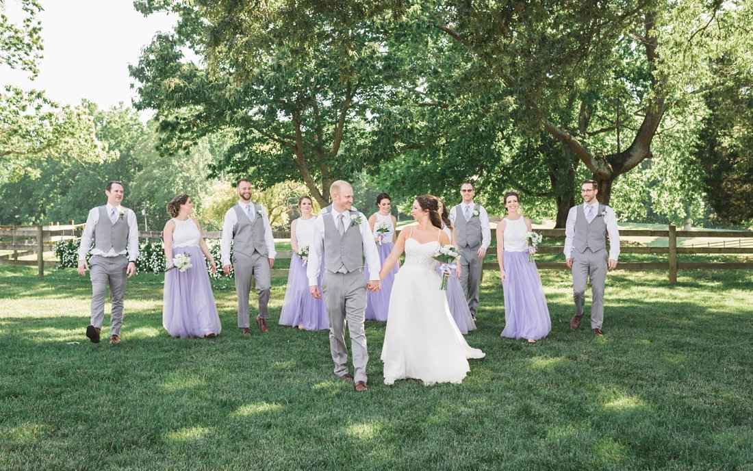 Bride and groom with their wedding party in the grass | Running Mare Farm Wedding