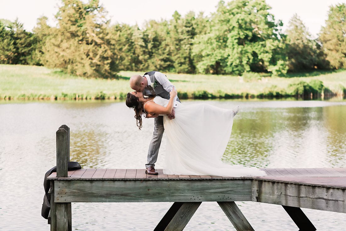 Bride & groom kissing on a dock | Running Mare Farm