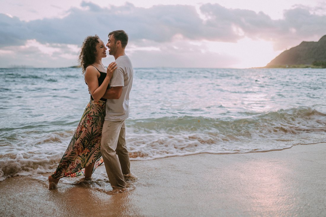 man and woman holding each other on the beach | beach engagement photos