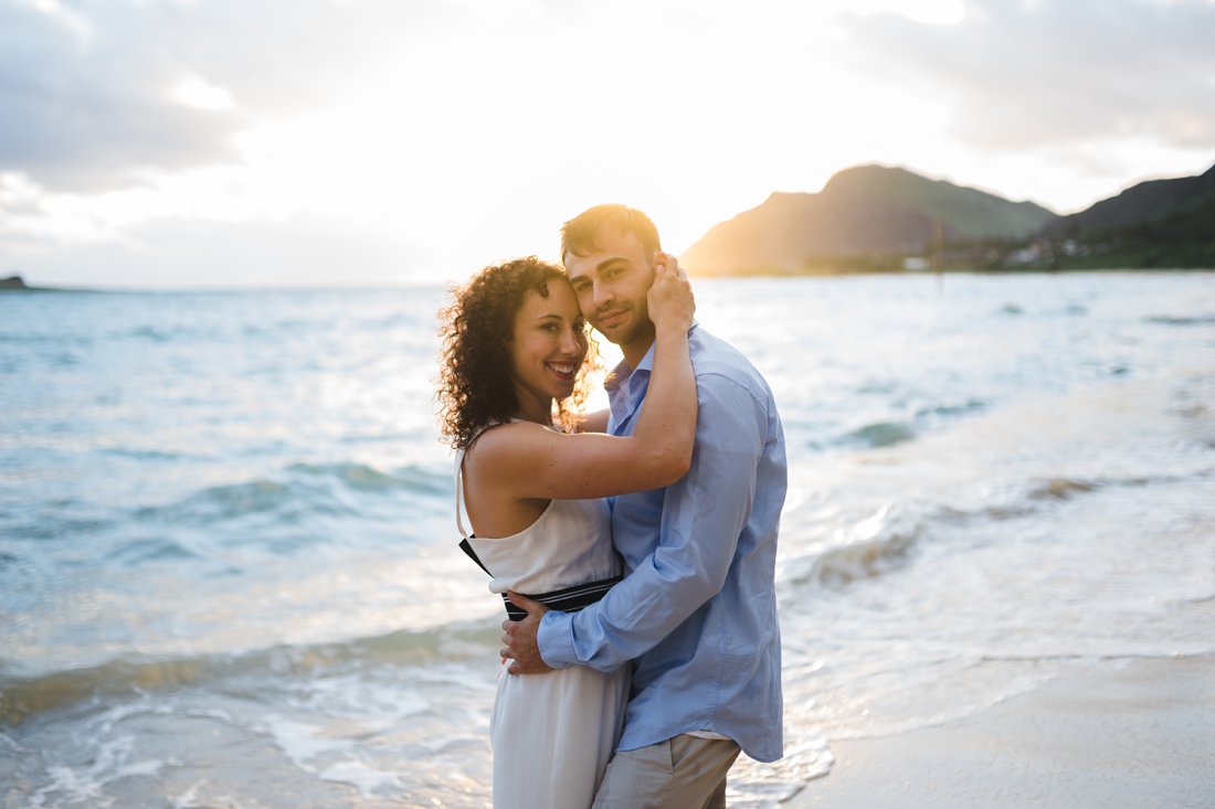 man and woman holding each other on the beach | beach engagement photos
