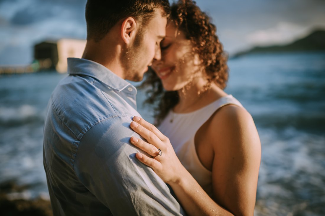 woman with hand on man's shoulder at beach | beach engagement photos