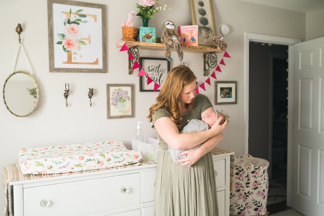 mom holding baby girl in nursery | Montgomery Alabama newborn lifestyle photographer