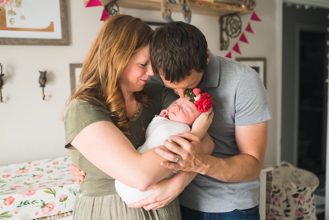dad kissing baby girl that mom is holding | Montgomery Alabama newborn lifestyle photographer