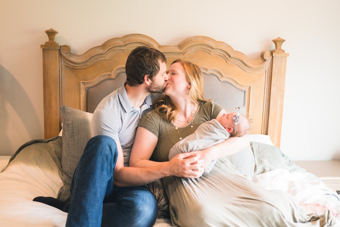 mom and dad kissing and holding new baby | Dayton Newborn Photographer