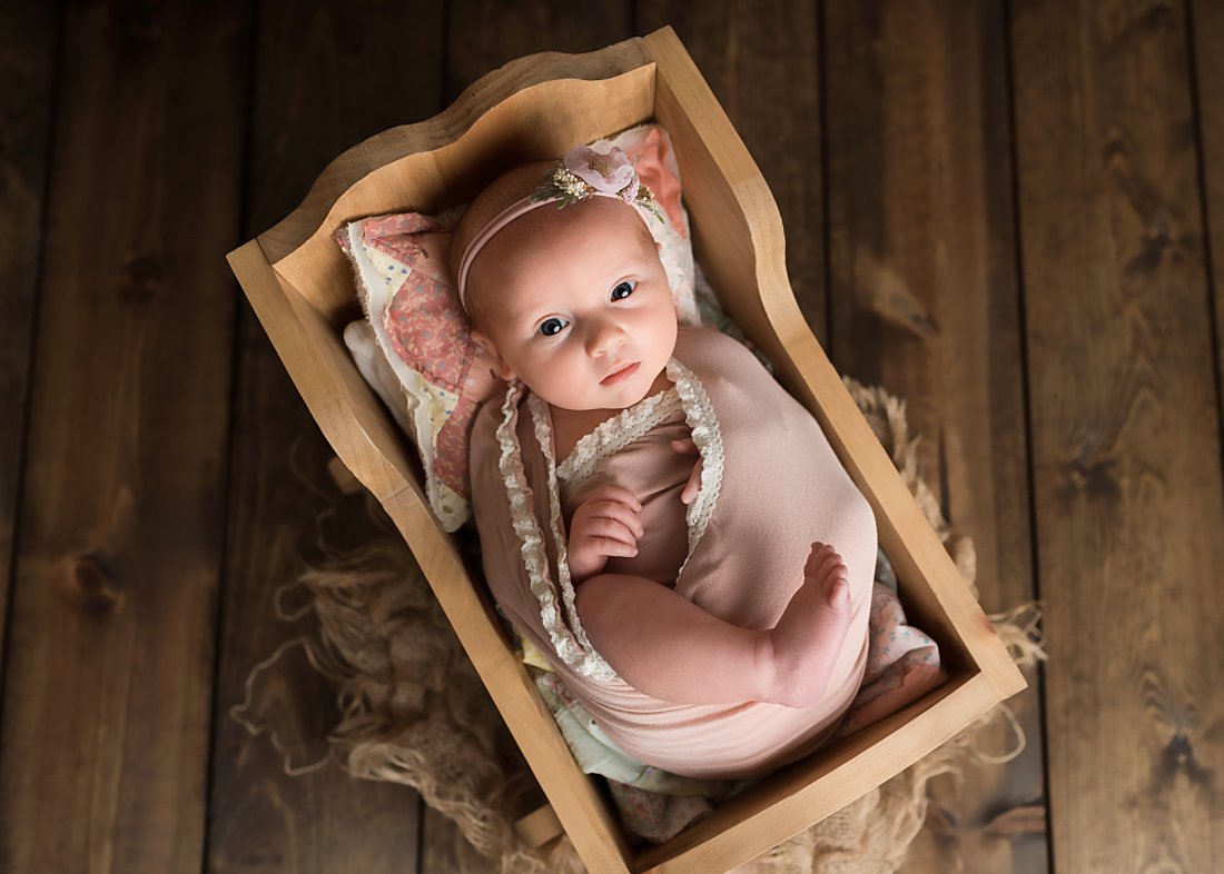 baby girl in pink in wooden cradle | Dayton Baby Photographer