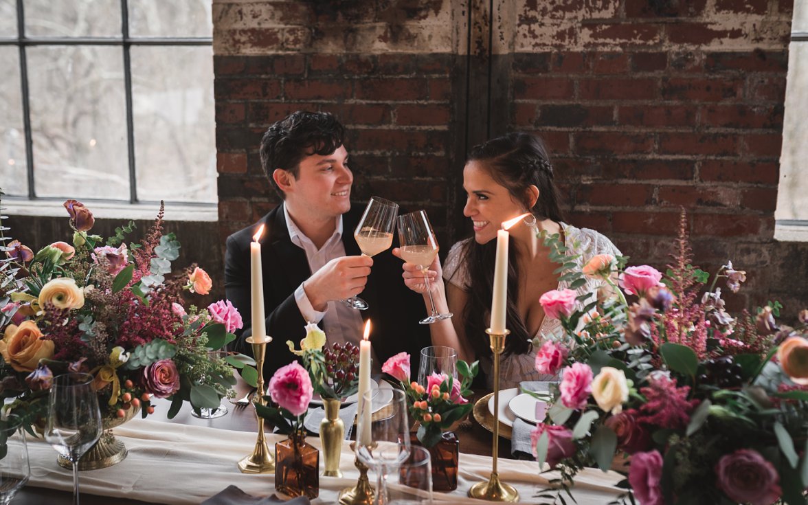 bride and groom toasting glasses with candles 