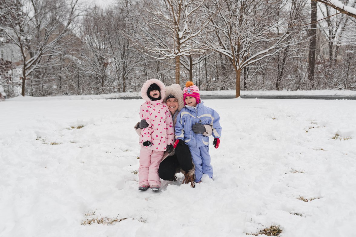 woman hugging children in winter in the snow | snow day