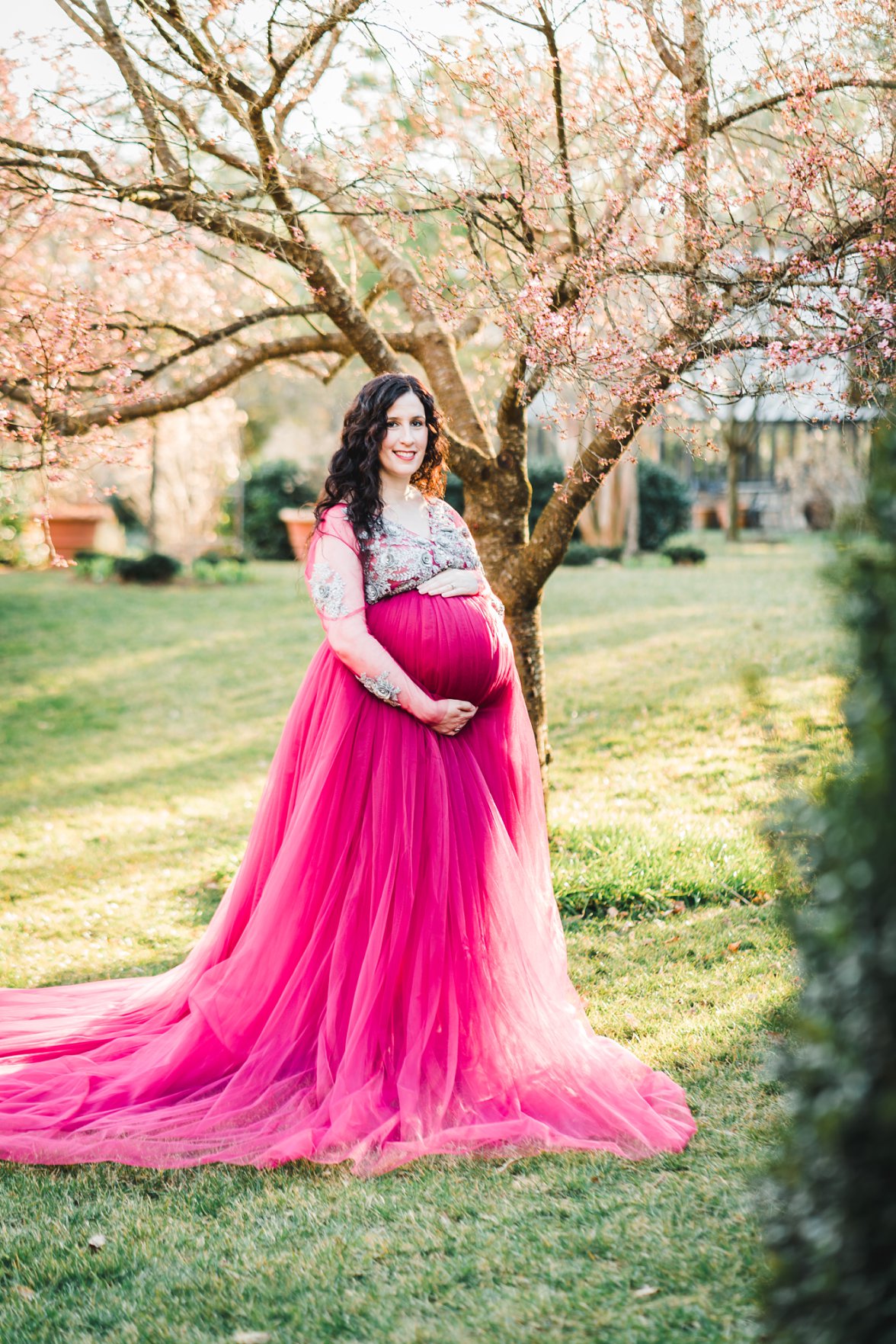 woman in front of blooming tree in maternity gown | Charlottesville Maternity Photographer