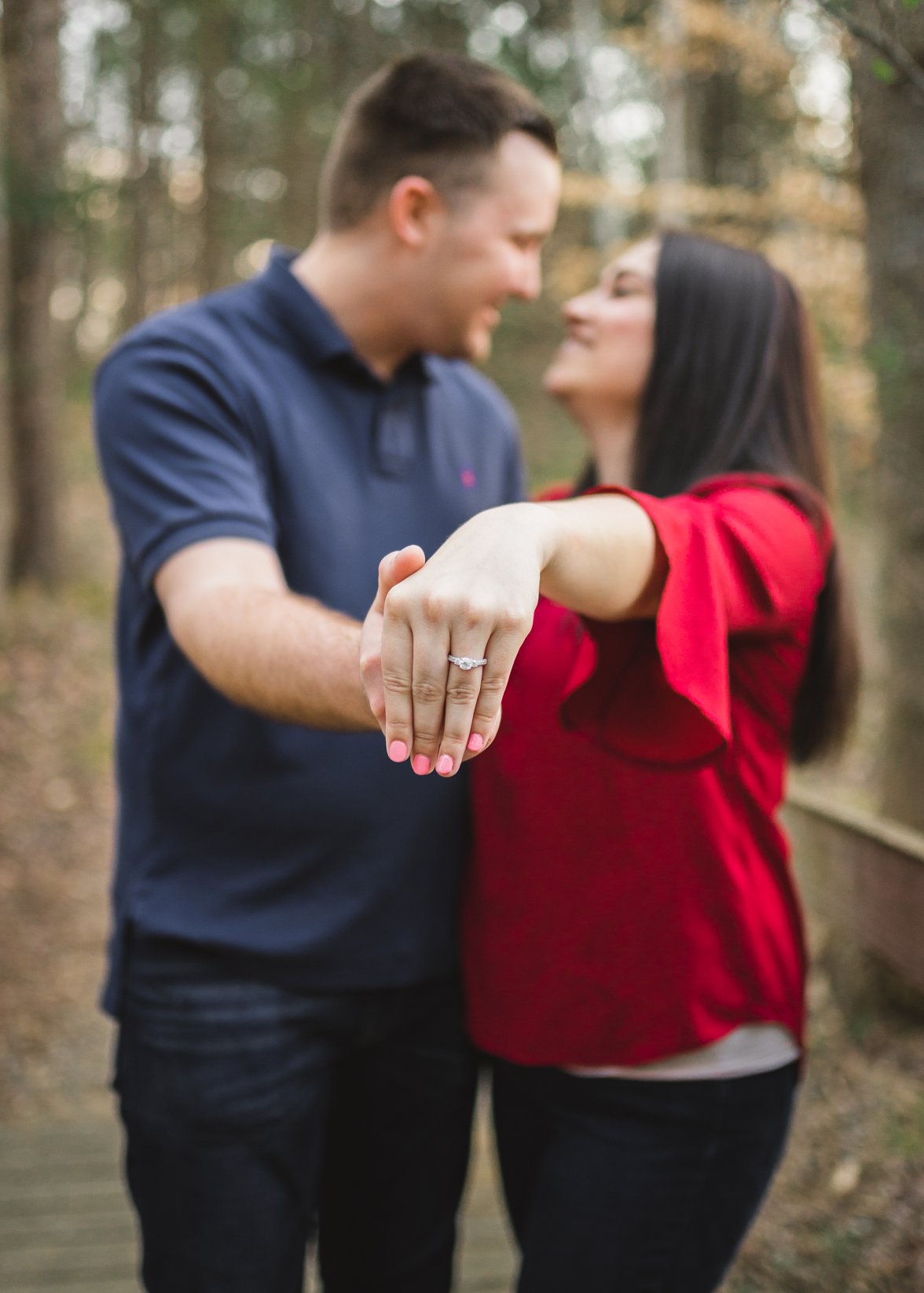Engaged Couple holding out engagement ring