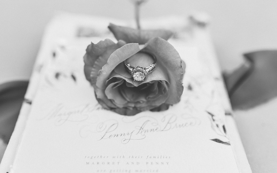 wedding ring in a rose on wedding invitation