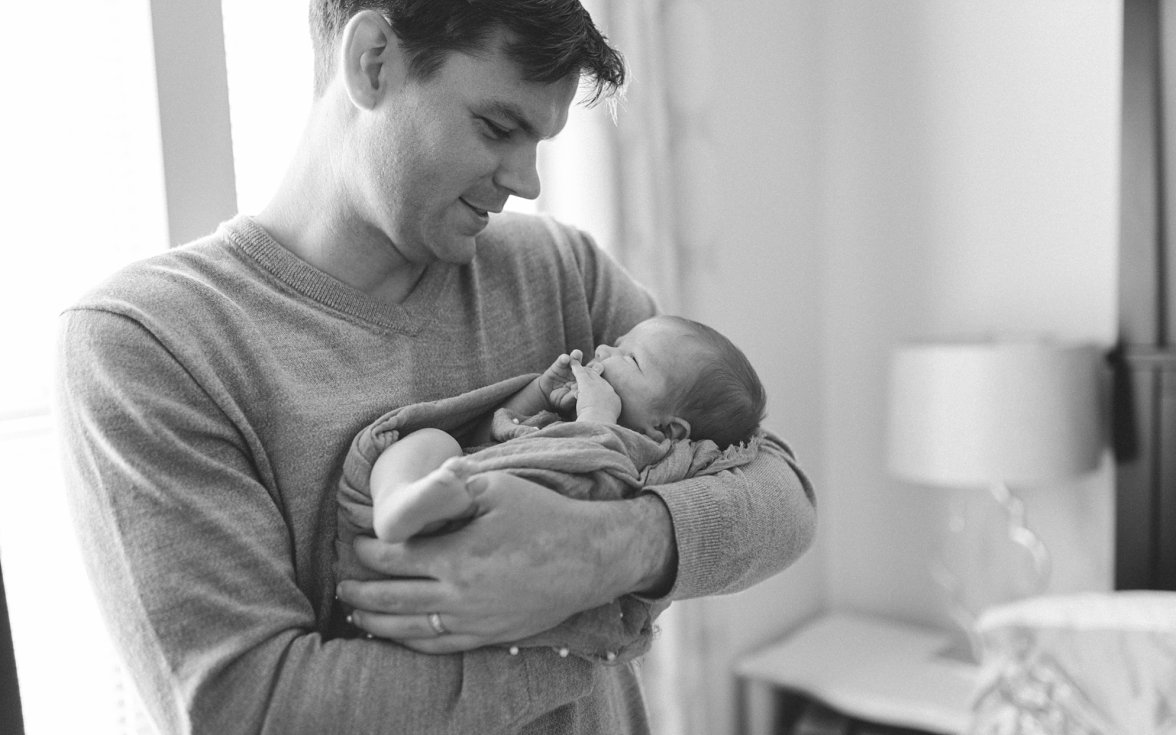 dad holding baby in arms | newborn lifestyle photography
