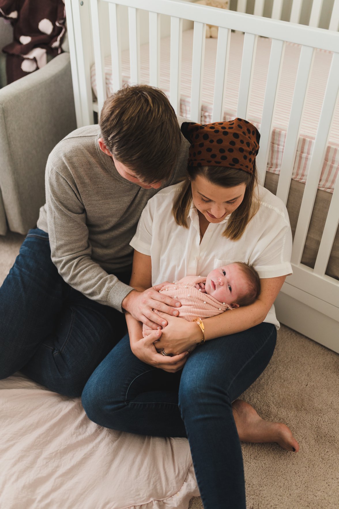 mom and dad holding baby girl in the nursery | Newborn Lifestyle Photography