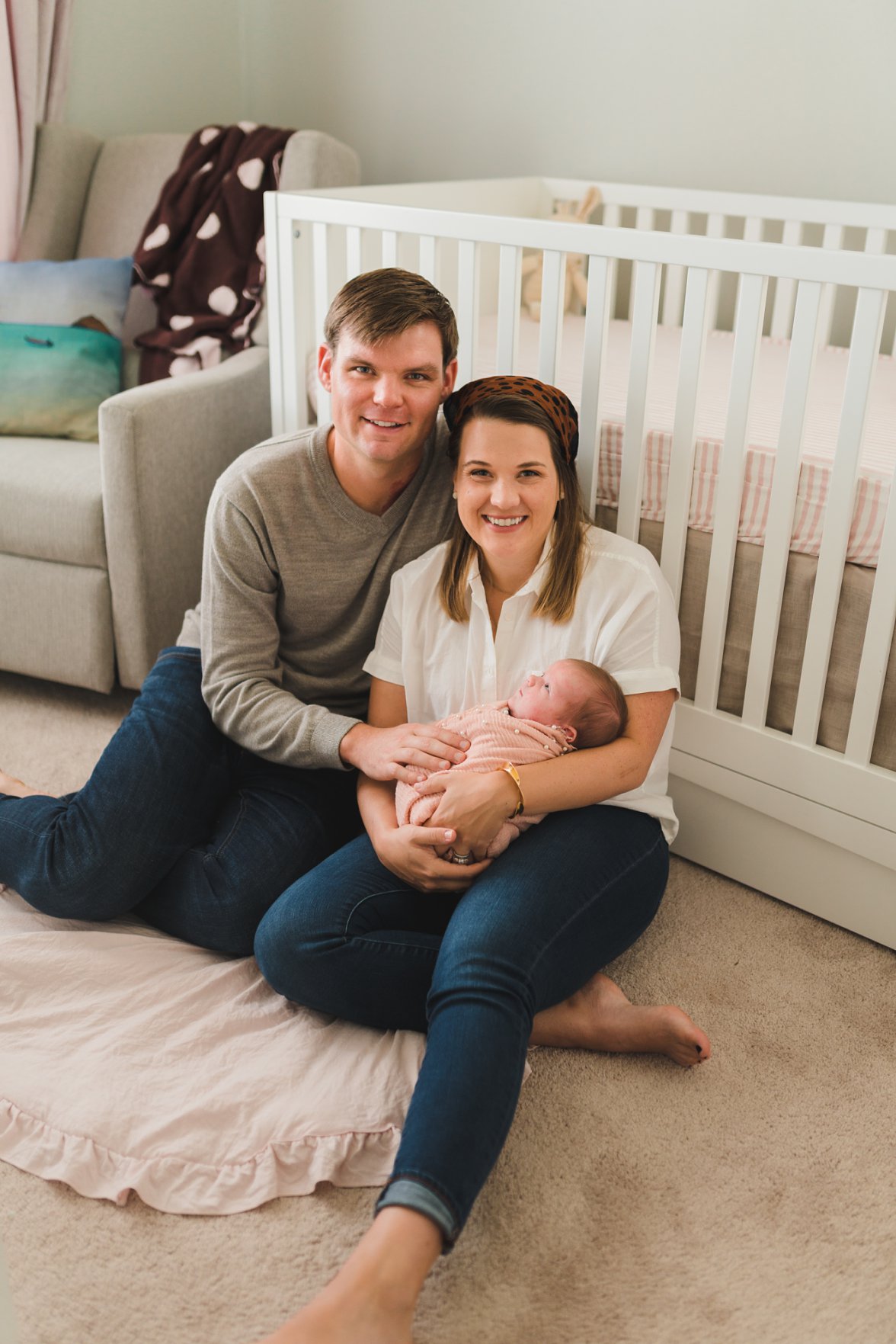 family of three sitting in baby nursery | Newborn Lifestyle Photography