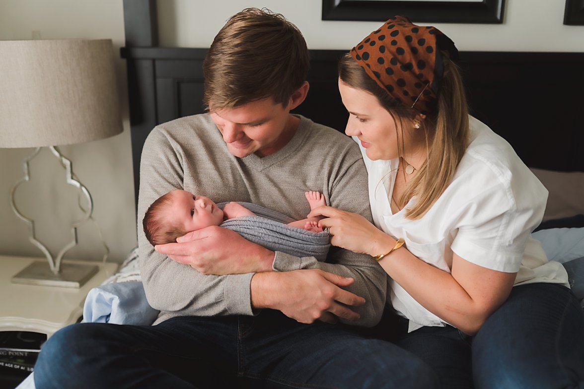 Dad holding baby and mom touching baby's feet | Newborn Lifestyle Photography