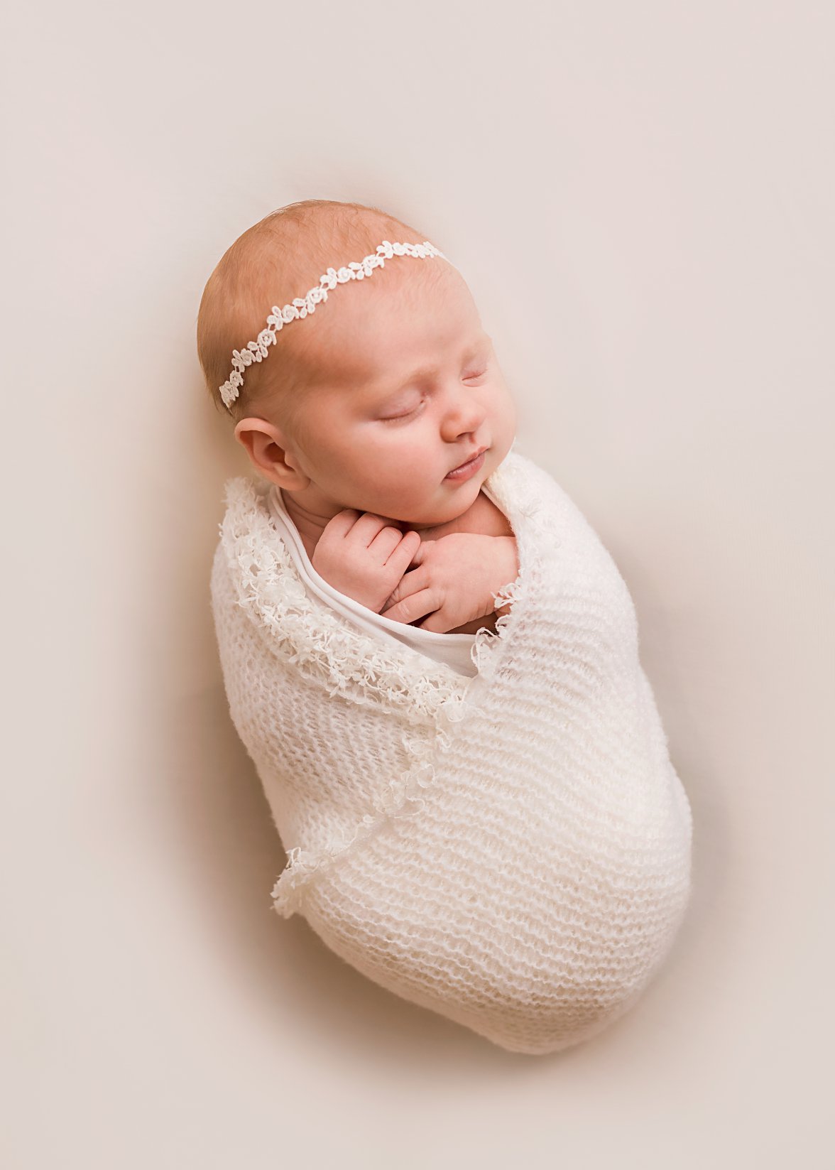 newborn baby girl in all white with lace headband