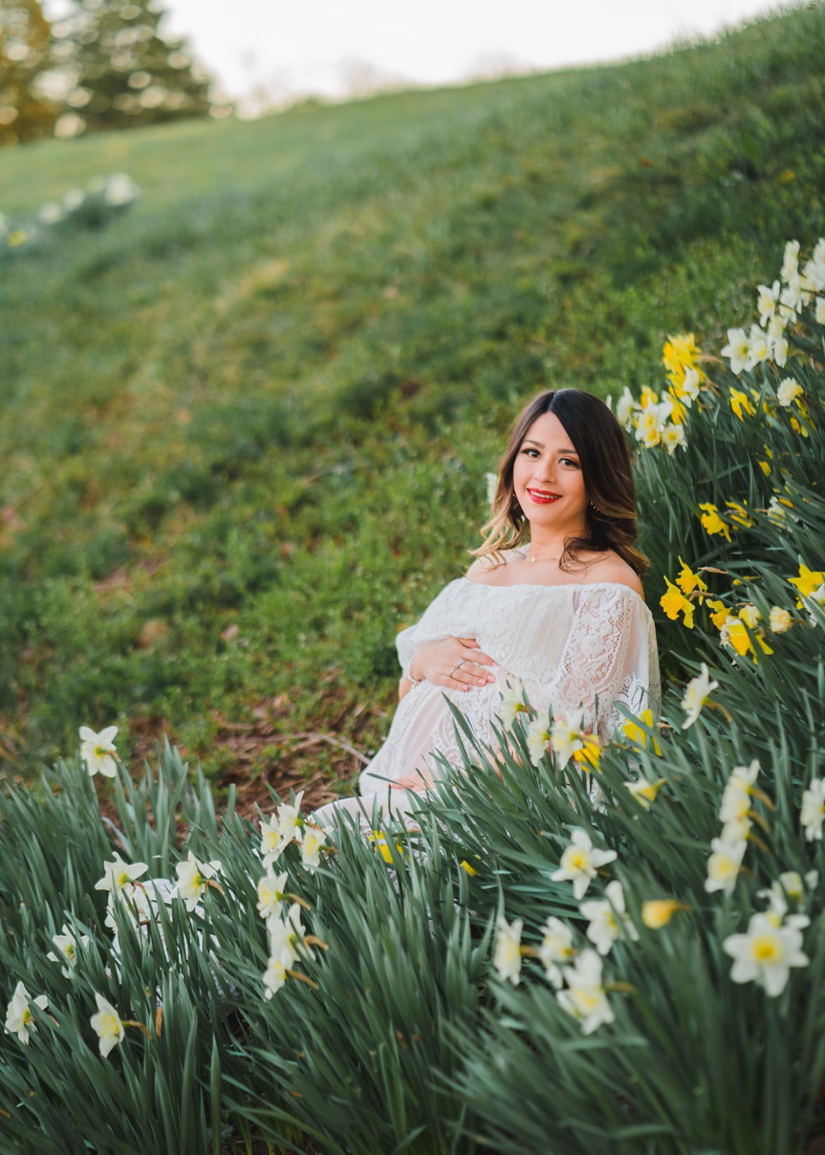 expecting mom sitting in daffodils | maternity photography dayton