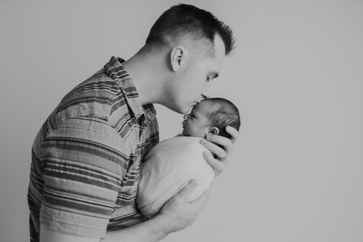 Black and white image of dad kissing baby's head | Melissa Sheridan Photography