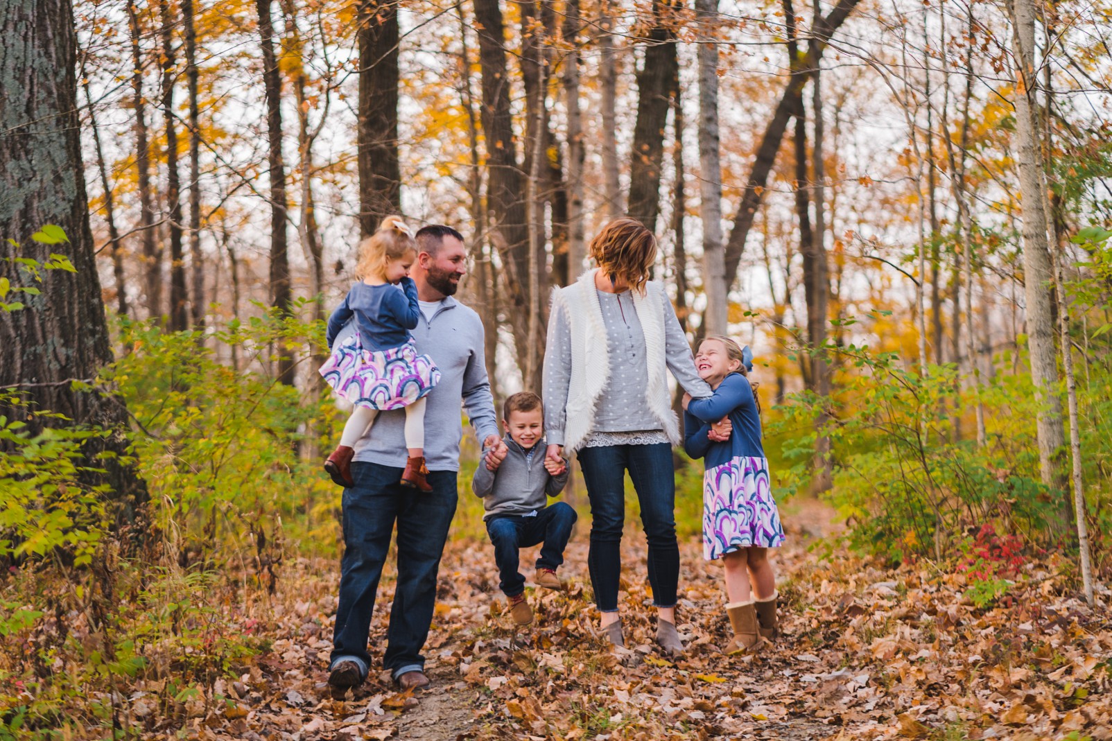 family standing in the leaves in a forest | Beavercreek Photographer